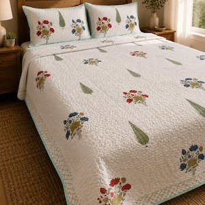 Peut inclure: Un couvre-lit matelassé blanc et deux taies d'oreiller assorties présentant un motif répétitif de bouquets de fleurs rouges et bleues entremêlés de feuilles vertes. L'ensemble de literie est bordé d'un liseré bleu turquoise clair.