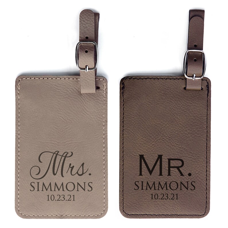 A personalized Mr. and Mrs. Luggage tag set is shown.  The leather luggage tags are tan and brown.  Luggage tags are gifts for a couple.  Each luggage tag is personalized with Mr or Mrs, the couple's last name, and the wedding date.