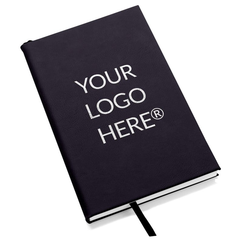 May include: Black leather-bound journal with a white bookmark. The cover has the text "YOUR LOGO HERE&reg;" printed in white.