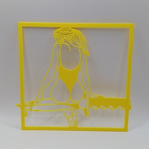 Könnte beinhalten: Gelbe, lasergeschnittene Silhouette einer Person im Badeanzug, die auf einer horizontalen Stange sitzt und sich anlehnt. Die Figur wird von einem gelben Rechteck umrahmt. Das Design ist minimalistisch und künstlerisch.