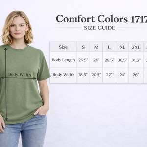 May include: A woman wearing a green Comfort Colors 1717 t-shirt, with a size guide chart. The chart shows body length and width measurements in inches for sizes S through 4XL. The shirt is olive green.