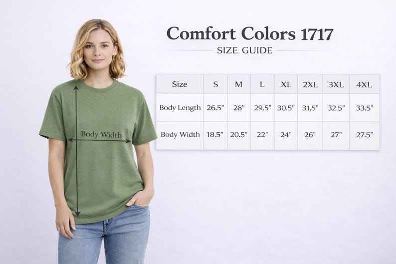 May include: A woman wearing a green Comfort Colors 1717 t-shirt, with a size guide chart. The chart shows body length and width measurements in inches for sizes S through 4XL. The shirt is olive green.