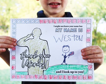 May include: A child holds a hand-drawn thank you card for veterans. The card features a soldier saluting, a stick figure holding a flag, and the text "I might not know your name but MY NAME IS WESTON and I look up to you!"