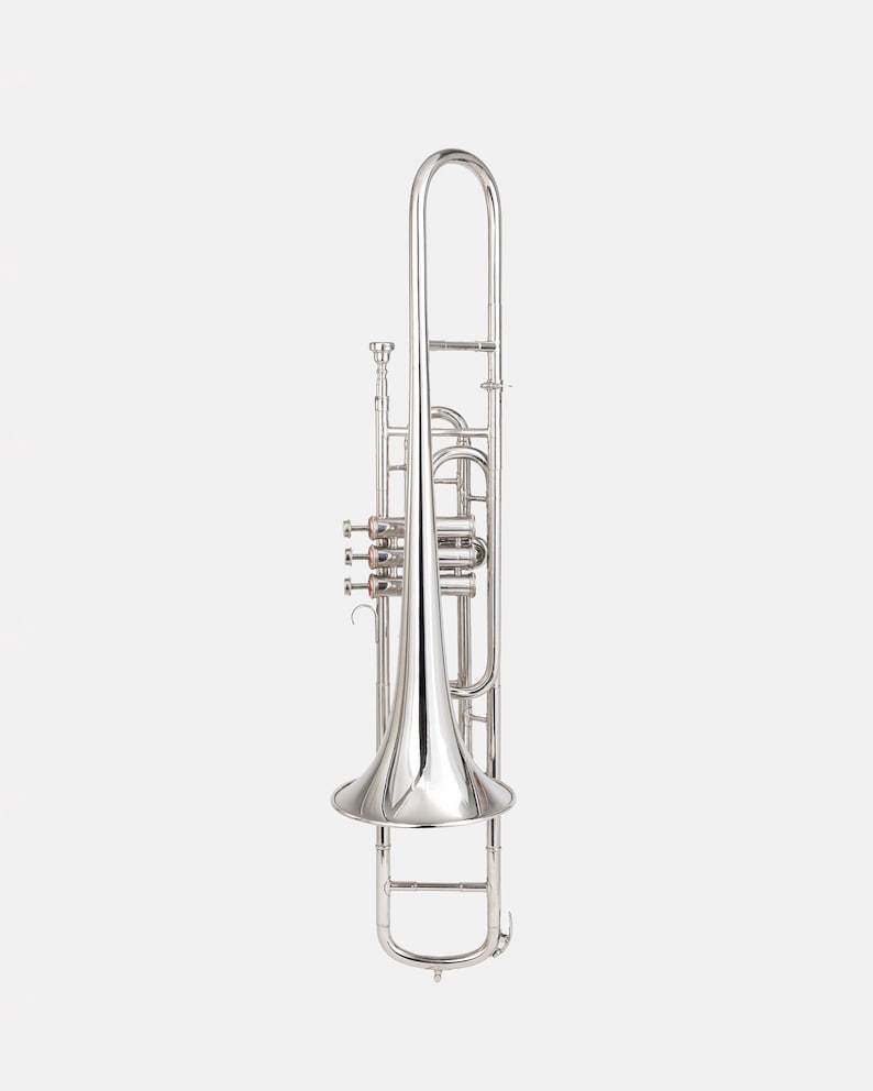 Puede incluir: Un brillante tromb&oacute;n plateado, un instrumento de viento metal, se muestra sobre un fondo blanco liso. El tromb&oacute;n presenta una campana, una vara y varias v&aacute;lvulas. La superficie pulida del instrumento refleja la luz, resaltando sus curvas y detalles. El tromb&oacute;n es un instrumento musical.