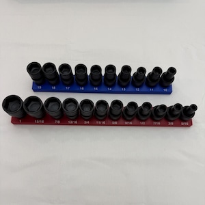 May include: A set of black metal socket tools arranged on two rectangular organisers. The blue organiser holds metric sockets labelled 10 through 19. The red organiser holds imperial sockets labelled 5/16 through 1 inch, with sizes printed in white.