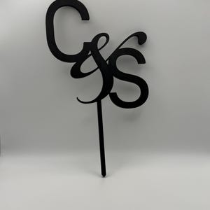 Peut inclure: Décoration de gâteau noire avec les lettres "C & S" dans une police cursive élégante. Les lettres sont reliées et montées sur un long pic fin pour être insérées dans un gâteau ou un dessert. Parfait pour les mariages ou les anniversaires.