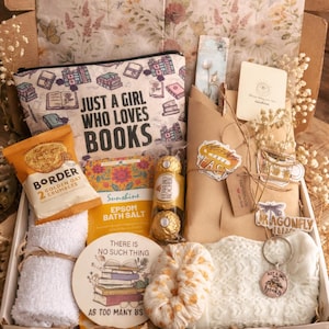 以下が含まれることがあります： 「JUST A GIRL WHO LOVES BOOKS」の文字が入ったコスメポーチ、Border Golden Oat Crumblesの袋、エプソムソルト、そして「THERE IS NO SUCH THING AS TOO MANY BS」と書かれたコースターなどが入ったギフトボックス。