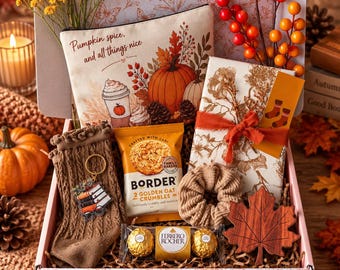 Op de afbeelding: Een geschenkdoos met een canvas etui met de tekst Pumpkin spice and all things nice, een paar bruine gebreide sokken, een boeken-sleutelhanger, een pakje Border koekjes, twee Ferrero Rocher chocolaatjes, een scrunchie en een onderzetter in de vorm van een esdoornblad.