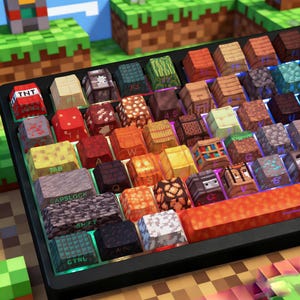 Peut inclure: Un clavier mécanique personnalisé avec des touches pixelisées de différentes couleurs et motifs. Les touches présentent des textures et des motifs en blocs rappelant un jeu vidéo. Certaines touches sont étiquetées avec du texte comme "TNT", "TAB", "CAPSLOCK", "SHIFT" et "CTRL".