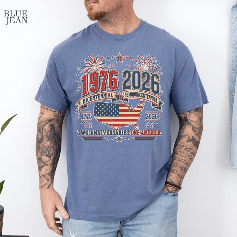 A man wearing a blue t-shirt with a graphic design celebrating the 1976-2026 Centennial Semicentennial of the United States.