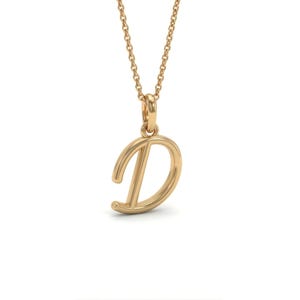 May include: A gold-coloured pendant necklace with the cursive letter "D". The pendant is suspended from a fine chain. The necklace is shown against a white backdrop, emphasising the jewellery's design.