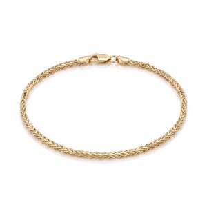 Könnte beinhalten: Ein goldenes Weizenkettenarmband mit polierter Oberfläche und einem Karabinerverschluss. Der Verschluss ist mit dem Text FIOR graviert. Das Armband ist kreisförmig und weist über die gesamte Länge ein durchgehendes, komplexes Flechtmuster auf.