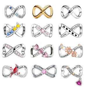 May include: A collection of twelve silver and gold-toned infinity-shaped charms. Each charm features unique engravings such as Forever, Family, and Love, along with decorative elements like colourful crystals, paw prints, hearts, and a red cardinal bird.