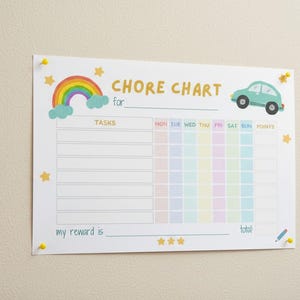 May include: A white chore chart with the words "CHORE CHART" and "for" in gold lettering. The chart features a rainbow, a teal car, and star illustrations. It includes spaces for tasks, days of the week, and a reward section.