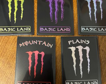 May include: Five black rectangular cards with different colored stylized claw marks and text. The cards read "FOREST", "SWAMP", "ISLAND", "MOUNTAIN", and "PLAINS" above the claw marks. Each card has the text "BASIC LAND" at the bottom.