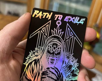 May include: A black rectangular card with the words "PATH TO EXILE" in a holographic, rainbow-colored font. The card features a detailed illustration of a hooded figure with a skull-like face. The artwork is in silver and white, with holographic accents.