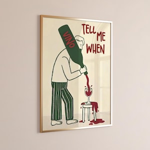Könnte beinhalten: Ein gerahmter Kunstdruck mit einer humorvollen Illustration einer Person, die Wein aus einer Flasche mit der Aufschrift "Vino" in ein Glas gießt. Der Text "Tell Me When" ist rot geschrieben. Die Person trägt ein weißes Hemd und eine gestreifte Hose.