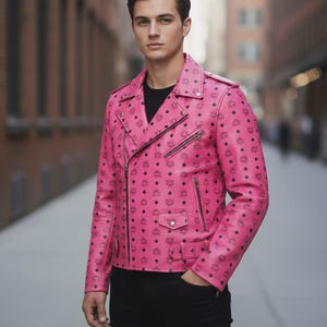 Könnte beinhalten: Eine pinkfarbene Lederjacke mit schwarzem Muster und Reißverschluss. Die Jacke hat einen klassischen Biker-Stil mit Reverskragen und mehreren Taschen. Das Model trägt ein schwarzes Hemd und eine schwarze Hose.
