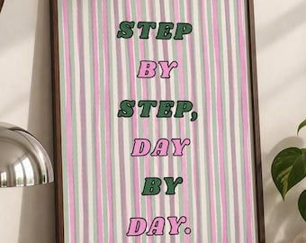 Puede incluir: Un cuadro rectangular con marco que presenta rayas verticales en tonos alternos de rosa claro, verde salvia y lavanda. El texto STEP BY STEP, DAY BY DAY está impreso en el centro con una fuente retro llamativa en color verde oscuro y rosa.