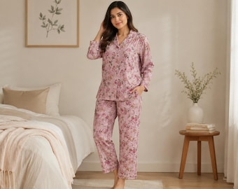 May include: A pink floral two-piece pajama set. The set features a button-down shirt with a notched collar and matching trousers. The floral pattern includes pink and burgundy hues. The pajamas are made of a lightweight fabric, perfect for a comfortable night's sleep.