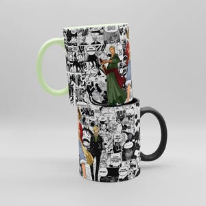 May include: Two stacked ceramic mugs. The top mug has a light green handle and interior, with a black and white manga design featuring characters in color. The bottom mug has a black handle and a similar manga design.