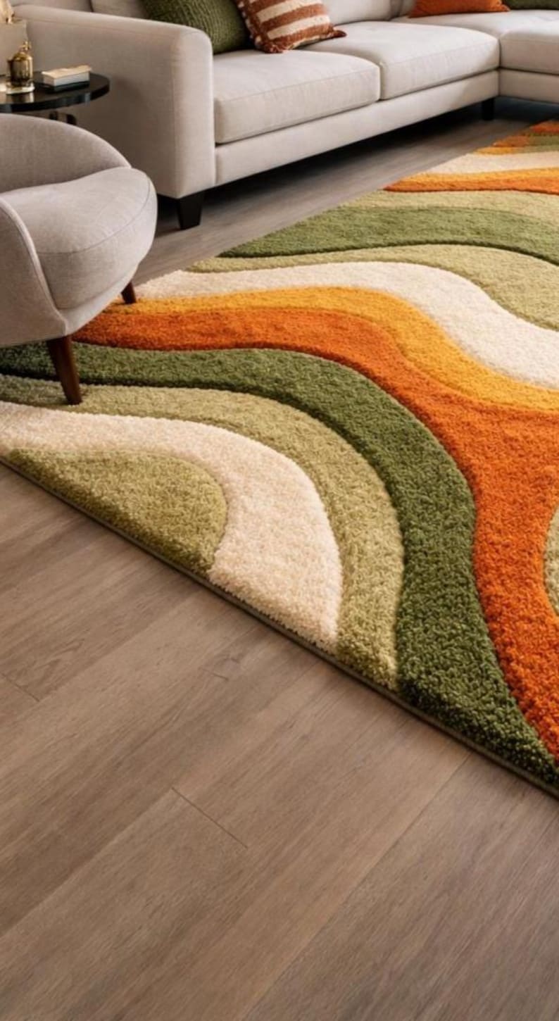 Abstract wave shaggy rug in olive green, orange, and cream colors placed in a modern living room with beige sofa and large windows