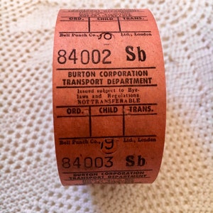 May include: A red and white paper ticket with the text "BURTON CORPORATION TRANSPORT DEPARTMENT" and the numbers "84002 Sb" and "84003 Sb".