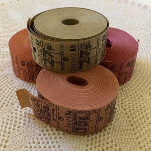 May include: Three rolls of vintage paper tickets. The top roll is brown with the text "50003 Ap City of Nottingham Trans." The middle roll is orange with the text "74001 Ma CHESTER CITY TRANSPORT." The bottom roll is red with the text "50004 Ap CONTROL ITEMS LTD."