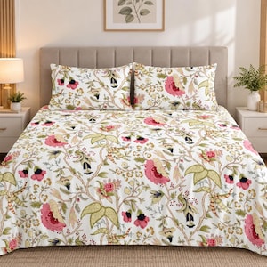 May include: A white bedspread and two matching pillowcases featuring a repeating botanical pattern of large pink flowers, green leaves, and brown winding branches. The bedding set is displayed on a bed with a tall, upholstered headboard.