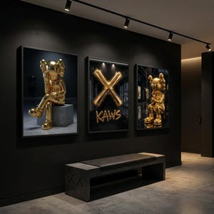 May include: Three framed artworks showcasing gold sculptures and a gold balloon "X" with the word "KAWS". The art hangs on a dark wall above a dark bench with a leather seat. The room has a modern, gallery-like aesthetic.