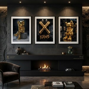 May include: Three framed art prints showcasing gold KAWS sculptures and a gold balloon X with the word "KAWS". The prints are displayed above a black fireplace with a burning fire.