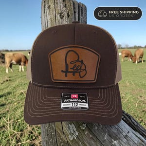 May include: A white ceramic mug with a black handle and the text "But First, Coffee" in a handwritten style. The mug is on a white surface. The mug is approximately 4 inches tall.