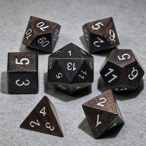 Pode incluir: Um conjunto de sete dados poliédricos de madeira castanho-escura com números gravados em prata. A coleção inclui um d20, d12, d10, d8, d6, d4 e um dado percentual, cada um com um acabamento liso e algarismos prateados claramente visíveis.