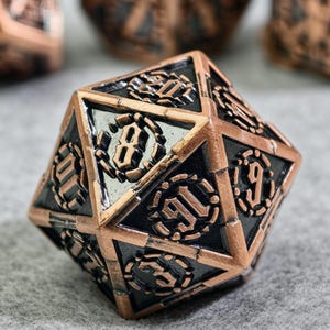 May include: A close-up of a copper-coloured, multi-sided die with black and silver accents. The die features intricate designs and numbers, including the number 8. The die is likely used for tabletop games.