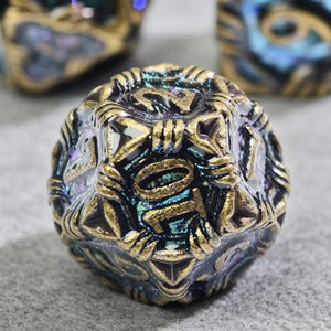 May include: Close-up of a multi-faceted, iridescent die with gold-colored accents. The die has a dark base color with a shimmering, oil-slick effect. The numbers are in gold, and the die appears to be for a tabletop game.