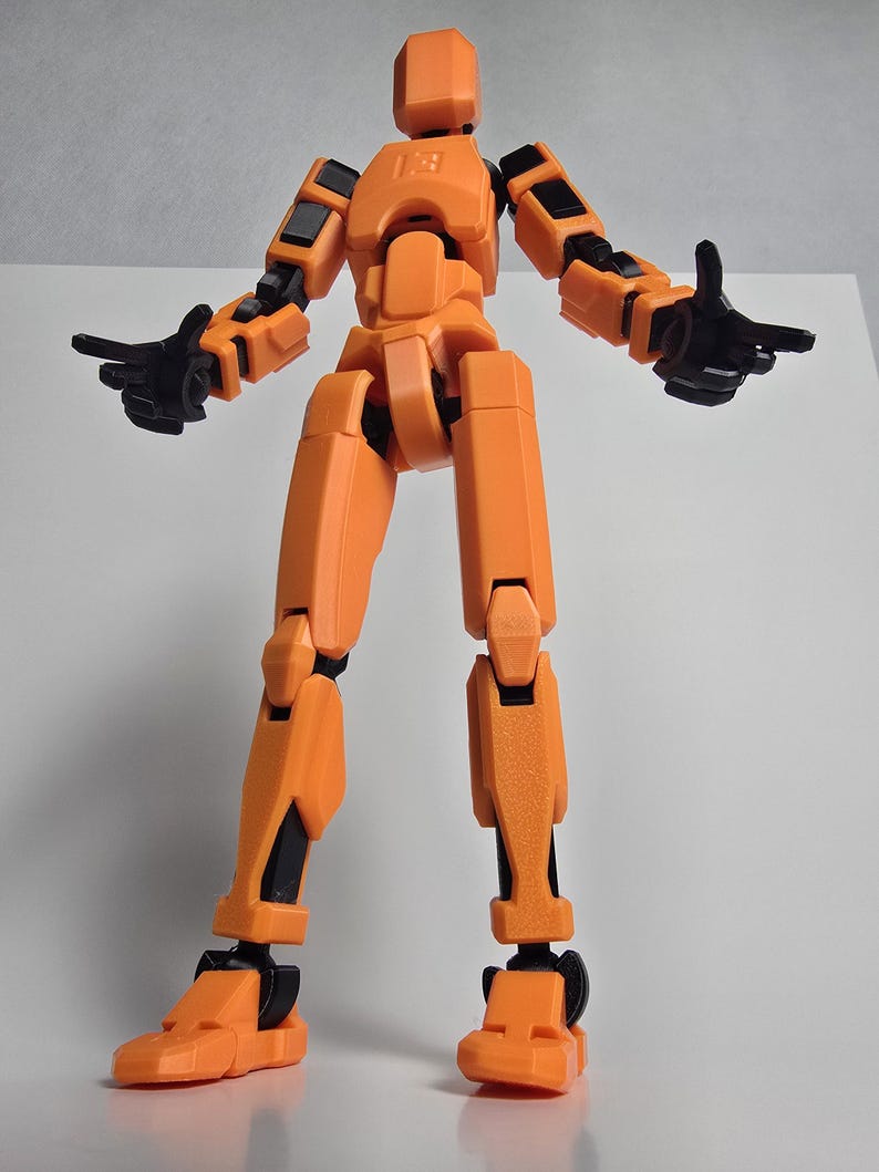 Heroic low-angle perspective of the 11-inch Titan Dummy 13 in Vibrant Orange. Highlights the massive scale, robust engineering, and industrial construction.