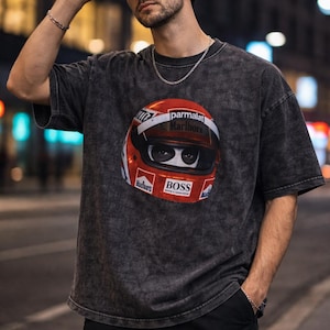 May include: Dark grey t-shirt with a red and white racing helmet graphic, including the words "parmalat Marlboro" and "BOSS". The shirt has a washed-out appearance and a crew neck.