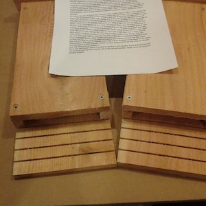 May include: Two wooden bat houses with instructions on how to place them correctly. The instructions mention that the bat houses should be placed in a location that is at least 17 feet high and has a south-facing direction. The instructions also mention that the bat houses should be placed in a location that is away from any trees or other structures.
