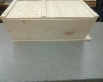 May include: A wooden box with a hinged lid. The box is made of unfinished pine wood and has a simple design.