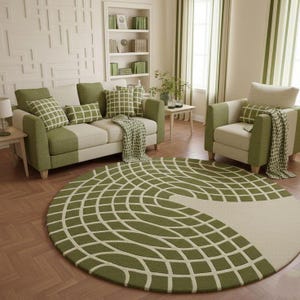 Könnte beinhalten: Ein Wohnzimmer mit Sofa, Sessel und rundem Teppich. Die Möbel sind grün und beige, ergänzt durch gemusterte Kissen und eine Decke. Der Teppich hat ein geometrisches Design. Der Raum ist in neutralen Tönen mit grünen Akzenten gehalten.