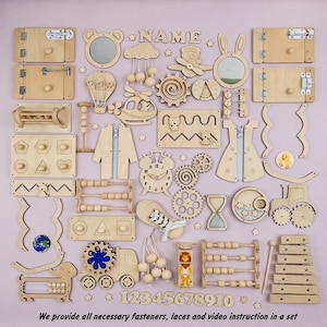 Könnte beinhalten: Eine Sammlung von Holzspielzeugen, darunter Formen, Zahnräder, Reißverschlüsse und ein Abakus, angeordnet auf einer rosa Oberfläche. Die Spielzeuge sind hellbraun mit verschiedenen Formen und interaktiven Elementen. Der Text "NAME" ist sichtbar. Die Zahlen 1-10 sind ebenfalls vorhanden.