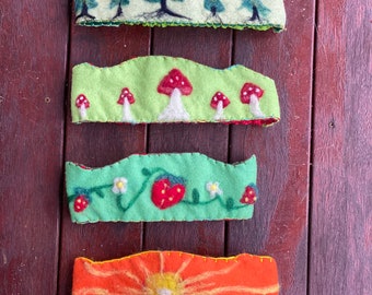 Simple Waldorf Birthday Crowns, featuring a sun, mushrooms, strawberries, and pine trees