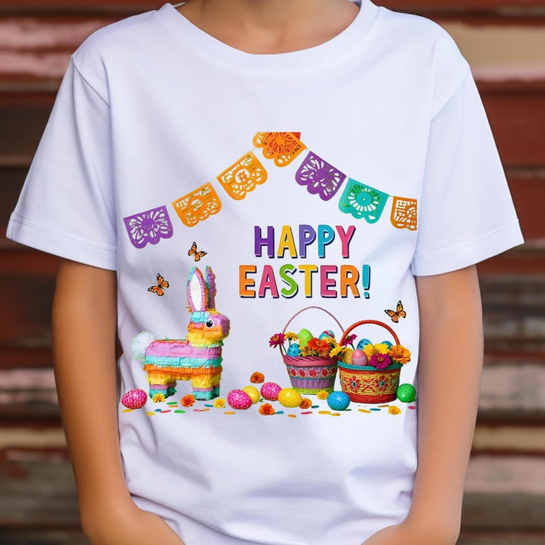 K&ouml;nnte beinhalten: Wei&szlig;es T-Shirt mit einem farbenfrohen Osterdesign. Die Grafik zeigt einen Pi&ntilde;ata-Hasen, K&ouml;rbe mit Eiern und Blumen, Schmetterlinge und den Text "HAPPY EASTER!" &uuml;ber einem dekorativen Banner.