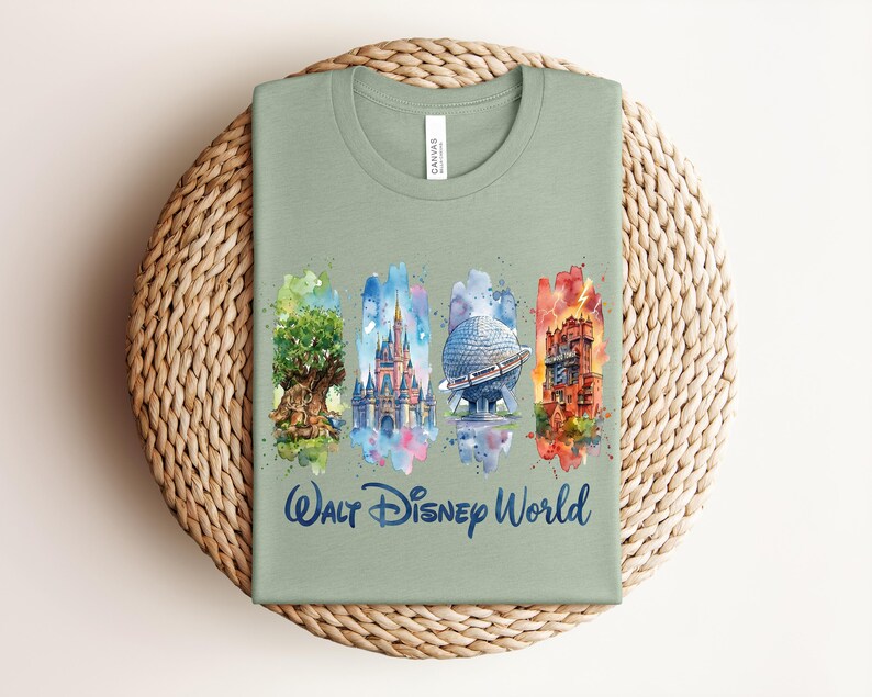 May include: Sage green t-shirt featuring watercolor illustrations of iconic Walt Disney World landmarks. The shirt includes images of the Tree of Life, Cinderella Castle, Spaceship Earth, and the Tower of Terror, with "Walt Disney World" written below.