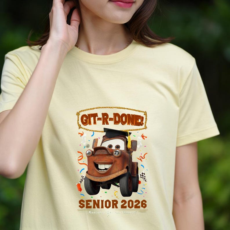 Op de afbeelding: Lichtgeel T-shirt met een cartoonafbeelding van Takel uit de film Cars, met een afstudeerhoed. De tekst "GIT-R-DONE!" staat boven de afbeelding en "SENIOR 2026" staat eronder. Confetti en afstudeergraphics omringen de afbeelding.