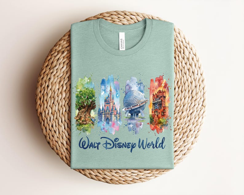 May include: A light green t-shirt featuring watercolor illustrations of iconic Walt Disney World landmarks. The design includes the Tree of Life, Cinderella Castle, Spaceship Earth, and the Tower of Terror, with "Walt Disney World" written below.