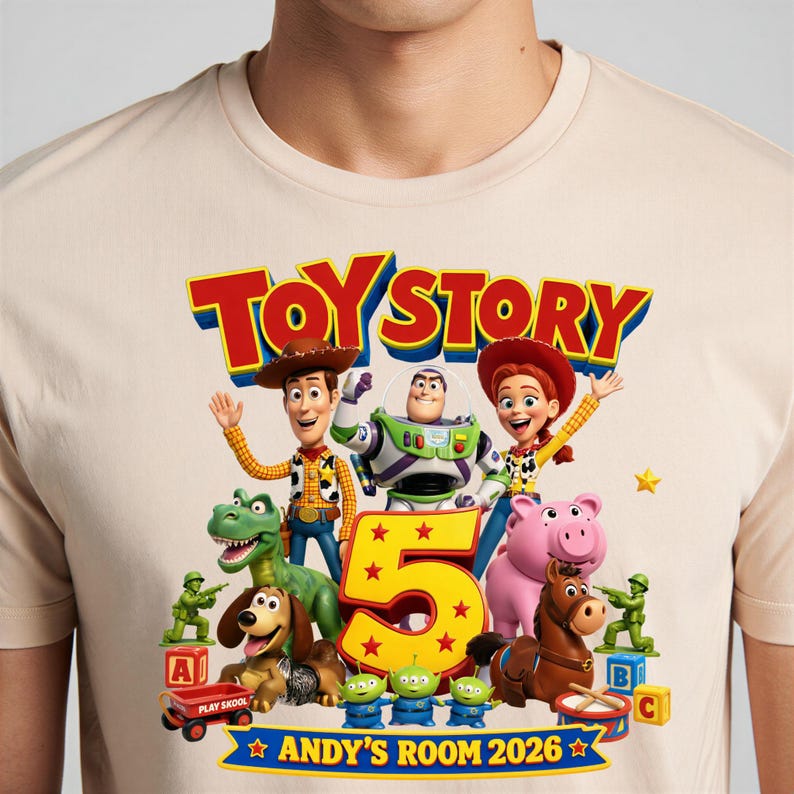 May include: A beige t-shirt featuring a colorful Toy Story graphic with Woody, Buzz Lightyear, Jessie, Rex, Slinky Dog, Bullseye, and three aliens. The design includes a large yellow number 5 and the text "TOY STORY" and "ANDY'S ROOM 2026".