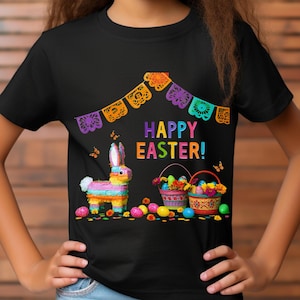 K&ouml;nnte beinhalten: Schwarzes T-Shirt mit einem farbenfrohen "Frohe Ostern!"-Motiv. Das Design umfasst einen Pi&ntilde;ata-Hasen, Osterk&ouml;rbe und dekorative Banner. Das Shirt ist mit Schmetterlingen und bunten Ostereiern verziert.