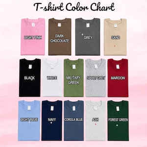 Op de afbeelding: Een T-shirt kleurenkaart met 14 gevouwen T-shirts met ronde hals in diverse kleuren, waaronder lichtroze, donkerchocolade, grijs, zand, zwart, wit, militair groen, sportgrijs, bordeauxrood, lichtblauw, marineblauw, corolablauw, as en bosgroen.