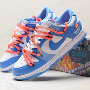 Dunk low bleu personnalisé style streetwear Design minimaliste gris et blanc peint à la main pour les amateurs de streetwear avec des lacets supplémentaires.